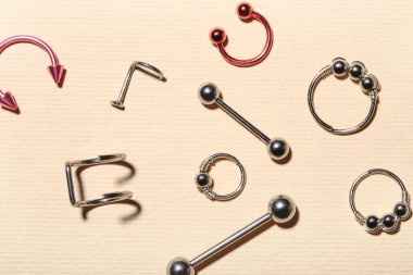 Renk arkaplanındaki piercing için şık mücevherlere sahip kompozisyon