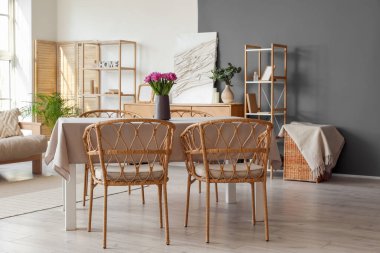 Odadaki yemek masasında lale olan vazo.