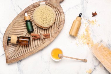 Ahşap tepside gerekli yağ şişeleri ve fayans zemininde bal