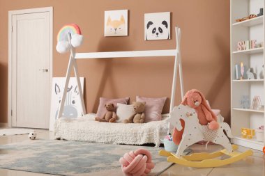 Rahat yatağı ve raf ünitesi olan modern çocuk odası.