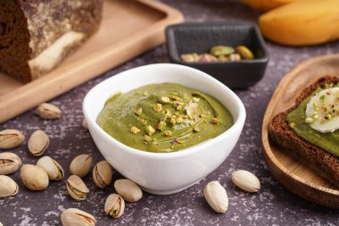 Gri grunge arka planda lezzetli şam fıstığı ezmeli kase.