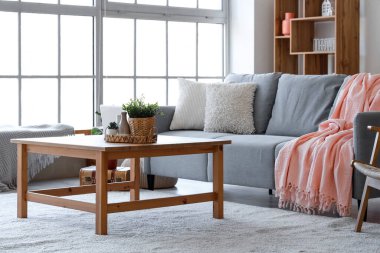 Konforlu kanepesi, çiçekleri ve kahve masası olan modern bir oturma odası.