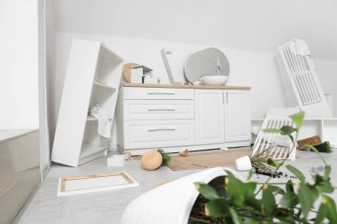 Ters çevrilmiş raf ünitesi ve dağınık banyodaki katlama ekranlı tezgahlar.