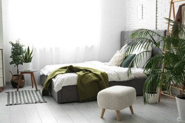 Şık yatak, güzel yatak odasında çiçekler ve yastıklar.