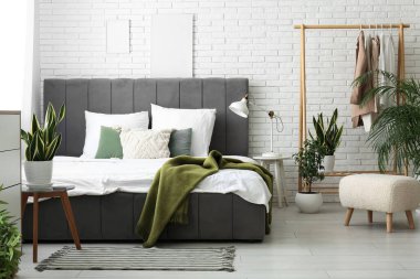 Şık yatak, güzel yatak odasında çiçekler ve yastıklar.