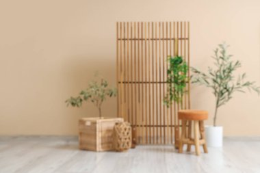 Konforlu koltuğu, çiçekleri ve ahşap perdesi olan şık bir oturma odası.