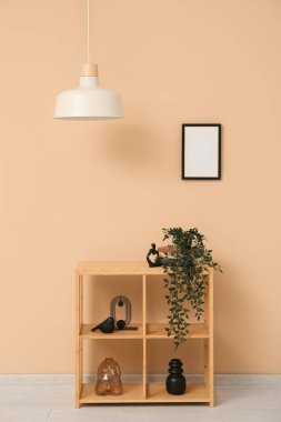 Asılı lamba, raflı ev bitkisi ve oda bej duvarının yanındaki çerçeve.