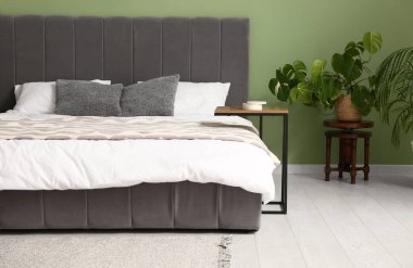 Şık, modern yatak odasının içinde temiz yatak ve ev bitkileri var.