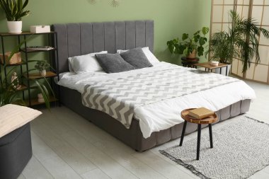 Şık modern yatak odası, temiz yatak odası, raf ünitesi ve ev bitkileri.