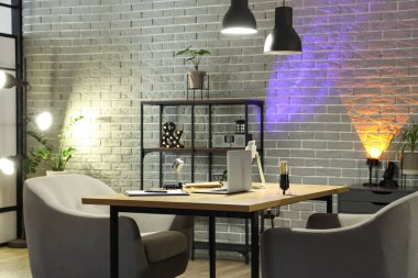 Podcaster 'ın iş yeri, raf ünitesi ve parlayan lambaları olan karanlık stüdyonun içi.