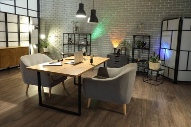 Podcaster 'ın iş yeri, raf üniteleri ve parlayan lambaları olan karanlık stüdyonun içi.