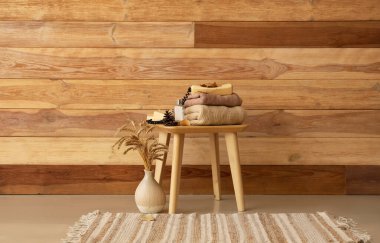 Kalın kıyafetler, klasik telefon, parfüm ve sonbahar dekoru ahşap duvarın yanında.