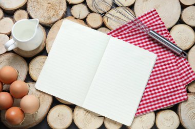 Boş tarif kitabı, mutfak gereçleri ve ahşap arka planda tavuk yumurtaları olan kompozisyon