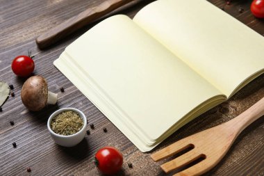 Boş tarif kitabıyla kompozisyon, ahşap arka planda sebzeler ve baharatlar