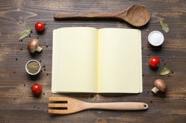 Boş tarif kitabı, çatal bıçak takımı, sebze ve baharatlı kompozisyon ahşap arka planda