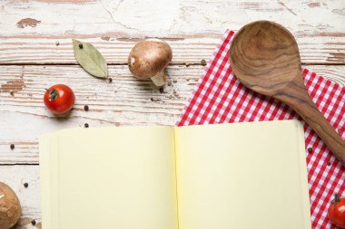Boş tarif kitabı, kaşık, sebze ve baharatlar hafif ahşap arka planda, yakın plan