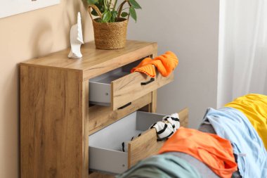 Dağınık kıyafetlerle dolu tuvalet dağınık oturma odasında.