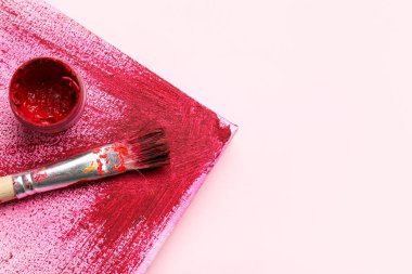 Pembe arka planda sanatçı fırçası, boya ve tuval, yakın plan
