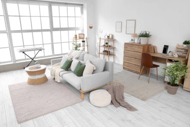 Gri kanepesi, kahve masası ve modern sentezleyicisi olan şık bir oturma odası.