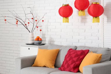 Çin Yeni Yılı için dekore edilmiş oturma odasının içinde kanepe ve masa var.