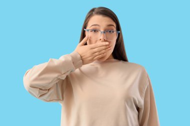 Mavi arka planda merak eden genç bir kadın