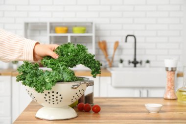 Mutfakta taze lahana yaprağı olan kadın eli.