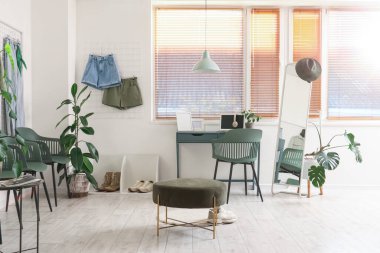 İş yeri, pim tahtası ve bitkileri olan giyim mağazasının içi