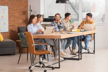 Genç iş adamları ofiste pazarlık yapıyor.