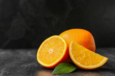 Taze portakallar ve siyah arka planda yaprak.