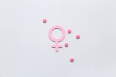 Arka planda hormonal hapları olan bir kadının kağıt sembolü.