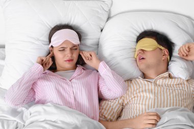 Evde kocasının gürültülü horlamasından rahatsız olan genç bir kadın.