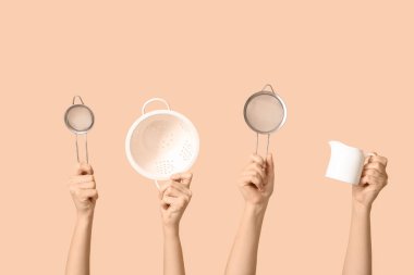 Bej arka planda süzgeç ve süt sürahisi ile elek tutan kadın elleri