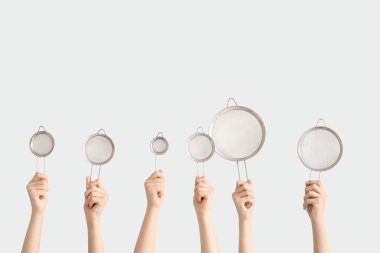 Beyaz arka planda süzgeçli kadın elleri