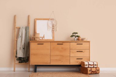 Modern odanın içinde şık bir elbise ve bej duvarın yanında merdiven var.