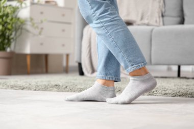 Kot pantolonlu kadın bacakları ve evde ısıtmalı çoraplar.