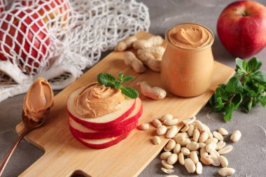 Elma mermileri, fıstık ezmesi, yerfıstığı ve nane yapraklı ahşap tahta.