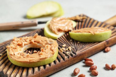 Lezzetli elma dilimleri, yuvarlak, fıstık ezmesi ve fıstık, yakın plan.