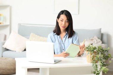 Güzel Asyalı kadın evde İngilizce öğreniyor.