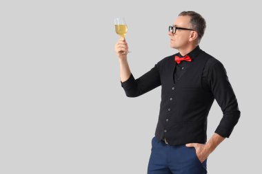 Hafif arka planda şarap kadehi olan olgun bir şarap garsonu.