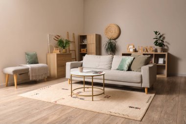 Gri kanepesi ve kahve masası olan modern oturma odasının içinde.