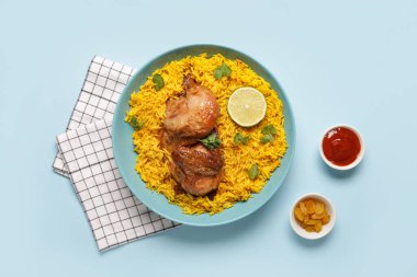 Mavi arka planda geleneksel tavuk biryani kasesi.