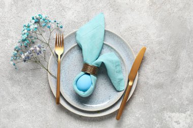 Paskalya için çok güzel bir sofra. Gri arka planda yumurta ve çiçekler var.