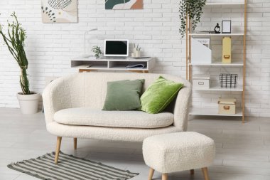 Rahat kanepesi, işyeri ve puf olan şık bir oturma odası.