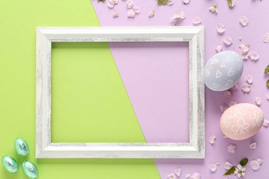 Çerçeveli güzel kompozisyon, boyanmış Paskalya yumurtaları ve renkli arka plan çiçekleri