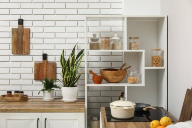 Elektrikli soba ve mutfak gereçleri olan şık bir mutfak.