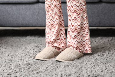 Gri terlikli kadın bacakları oturma odasında, yakın plan.