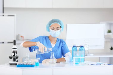 Profesyonel cam takımlı genç bir bilim adamı araştırma laboratuarında su kalitesini inceliyor.