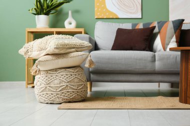 Şık oturma odasında yumuşak yastıklı gri kanepe.