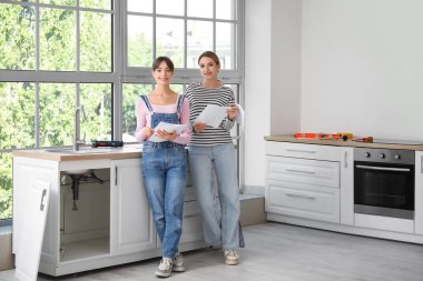 Mobilyalı genç kadınlar mutfakta talimat hazırlıyorlar.