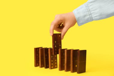 Kadın sarı arka planda domino taşından iniyor